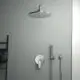 Große, runde Duschtasse in Chromfarbe von Ideal Standard, installiert an einer modernen Wand; ausgestattet mit einer Handbrause und einem Wandthermostat.